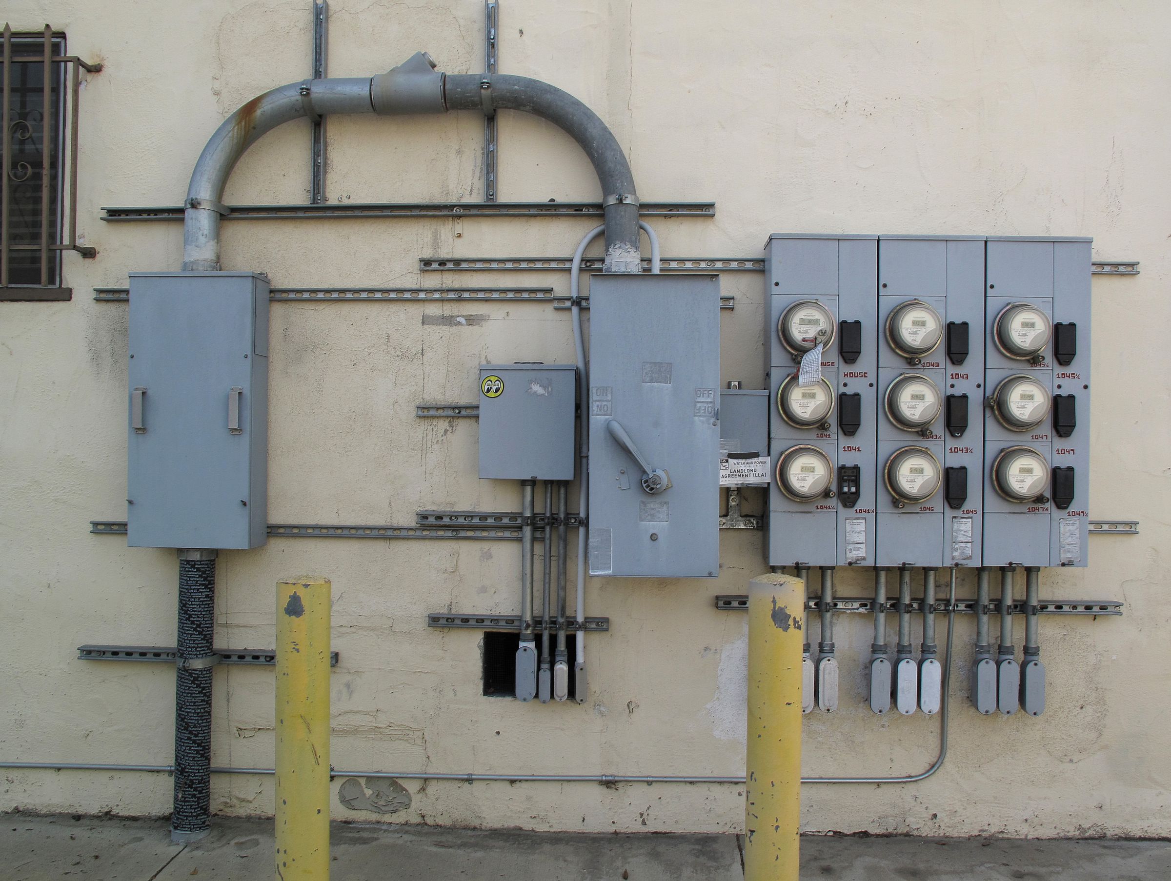 Bir binanın dış cephesinde sıralanmış elektrik sayaçları ve şalter panoları
